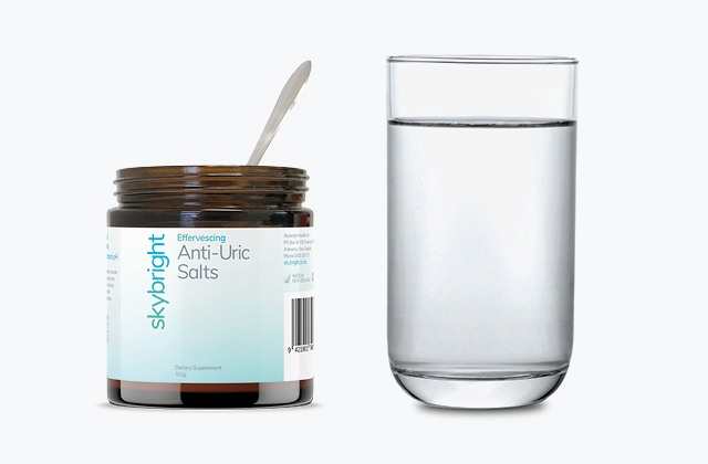 Skybright Anti-Uric Salts next to a glass of water.