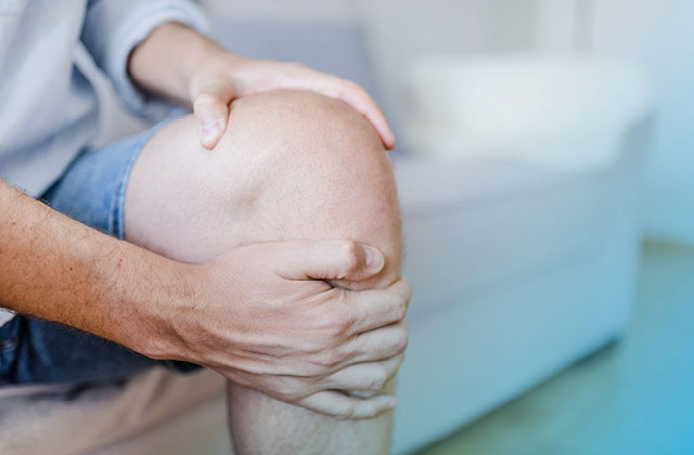 Man clutching knee with inflammation.