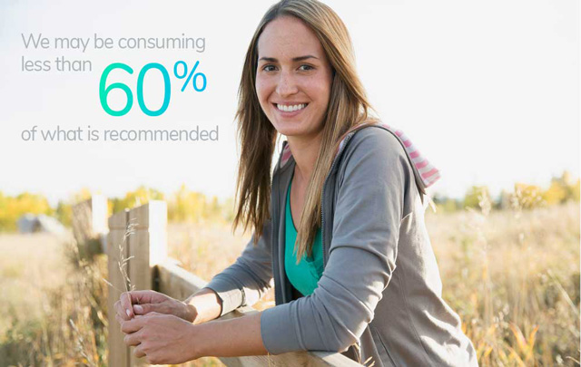 Woman smiling and leaning on fence in countryside. 