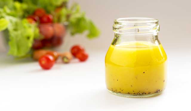 Jar of home-made Vinaigrette on a table.