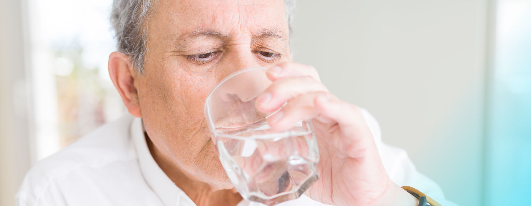 Man drinking Skybright Anti-Uric Salts from a glass of water 