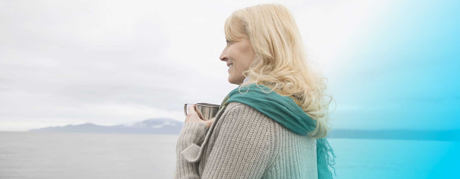 Woman holding mug and looking out to sea. Are you getting enough iodine?