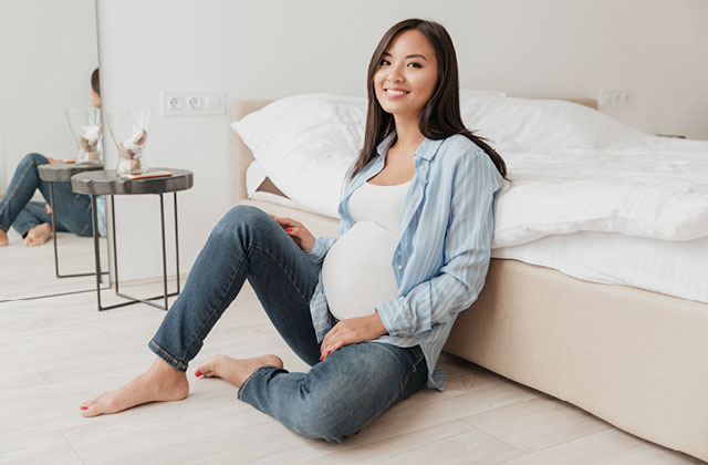 Pregnant woman sitting on floor in bedroom. 20-30% of women of child-bearing age may be iron-deficient in New Zealand.