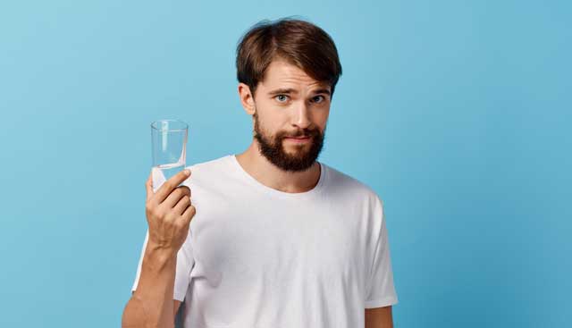 Man holding glass of water.