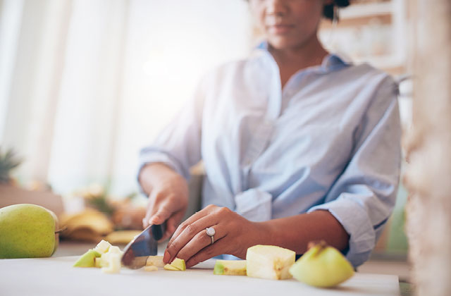 Woman chopping apples on chopping board. Clean with Colloidal Silver to keep bacteria free.