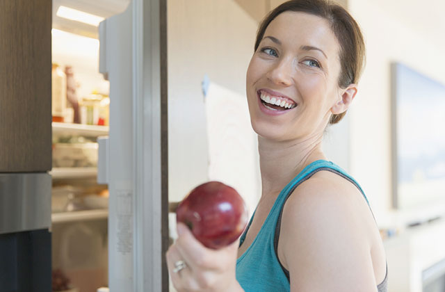 Woman taking apple from refrigerator. Spraying Colloidal Silver on fruits and vegetables can delay mould growth and keep them fresher for longer.