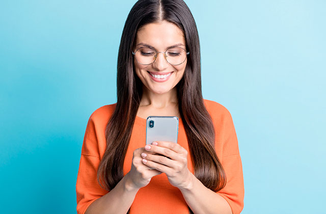 Woman holding mobile phone on a blue background. Using a clean cloth and Colloidal Silver liquid, wipe down your mobile phone to keep it free from bacteria.