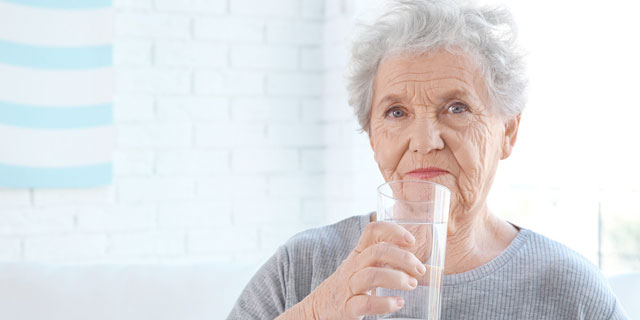 Woman drinking Skybright Selenium liquid mineral supplement.