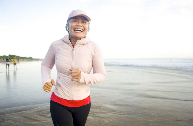 Woman running on New Zealand beach. Iron for energy.