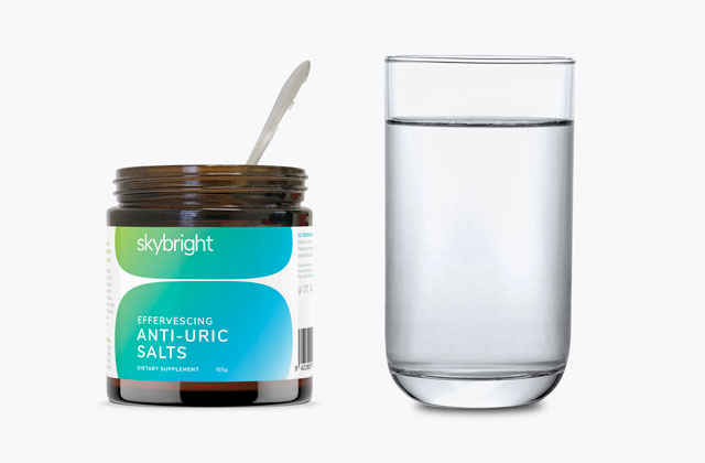 Skybright Anti-Uric Salts next to a glass of water.
