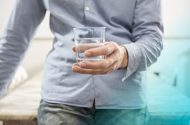 Man holding glass of water with added mineral supplements.
