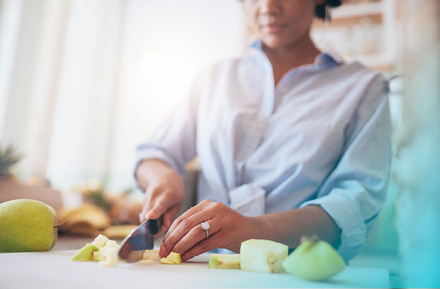 Woman slicing apples in kitchen.