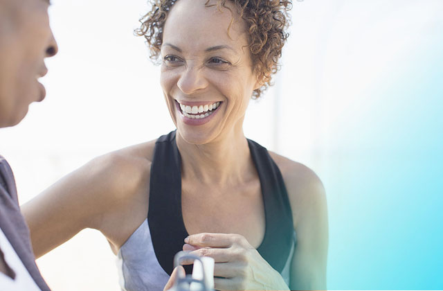 Smiling woman taking liquid mineral supplements.