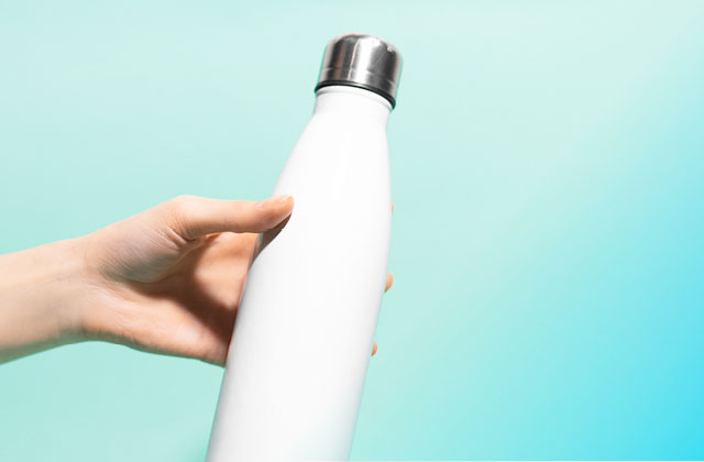 woman holding water bottle. Add you minerals and sip throughout the day to enhance absorption.