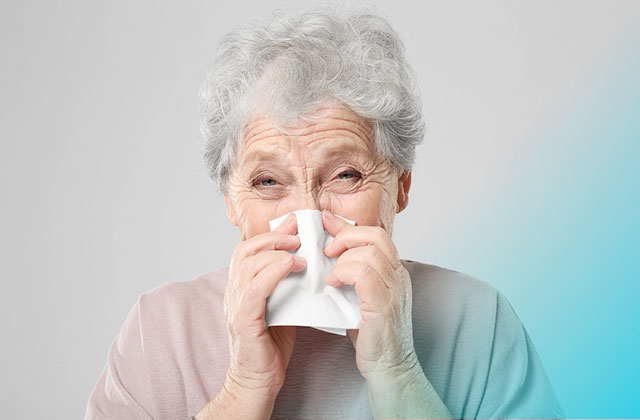 Woman with cold blowing her nose.